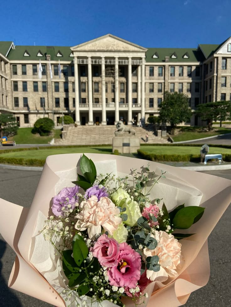 a bouquet of flowers sitting in front of a large building