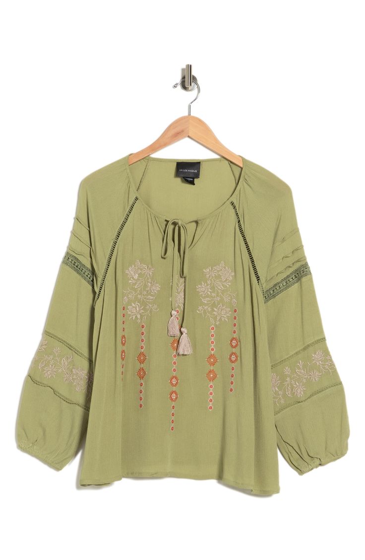 A beautifully embroidered tunic top features a keyhole tie neck and balloon sleeves for boho-chic style. 26" length (size M) Split neck with tassel ties Long raglan balloon sleeves with elastic cuffs Front keyhole Embroidered Inset ladder and lace trim Textured woven construction 100% rayon Hand wash, line dry Imported Model stats: 5'10" height, 32" bust, 25" waist, 36" hip. Model is wearing size M. Summer Embroidered Top With Blouson Sleeves, Spring Bohemian Embroidered Tunic Top, Spring Bohemian Embroidered Peasant Top, Bohemian Embroidered Peasant Top For Spring, Bohemian Spring Embroidered Tunic Top, Bohemian Peasant Top With Floral Embroidery For Spring, Green Long Sleeve Tops With Embroidered Neckline, Green Long Sleeve Top With Embroidered Neckline, Flowy Bohemian Embroidered Top For Spring