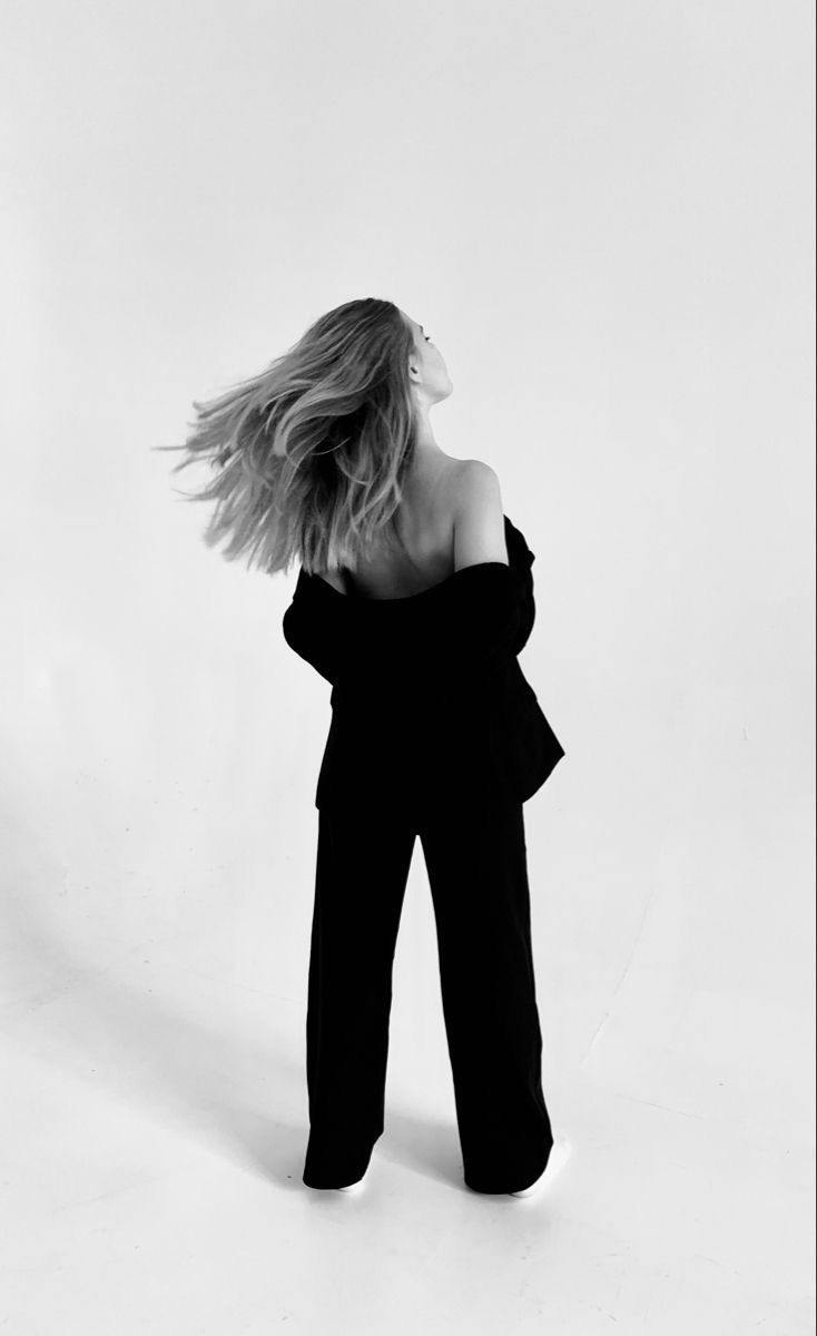 black and white photo of woman in off shoulder top with hair blowing in the wind