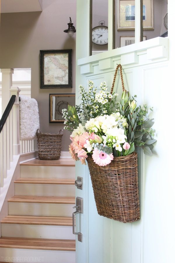 a basket with flowers hanging from the side of a stair case next to a set of stairs