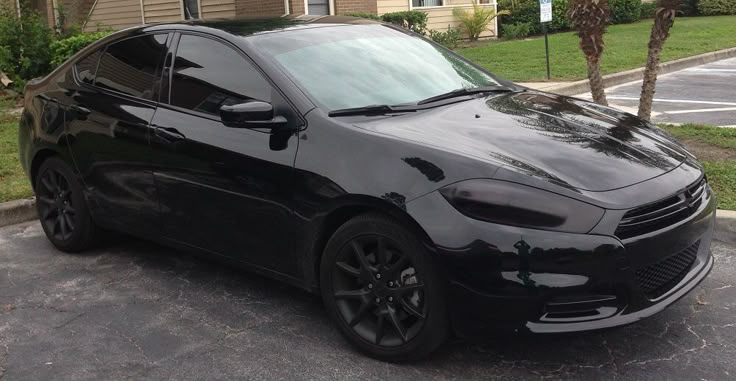 a black car parked in front of a house