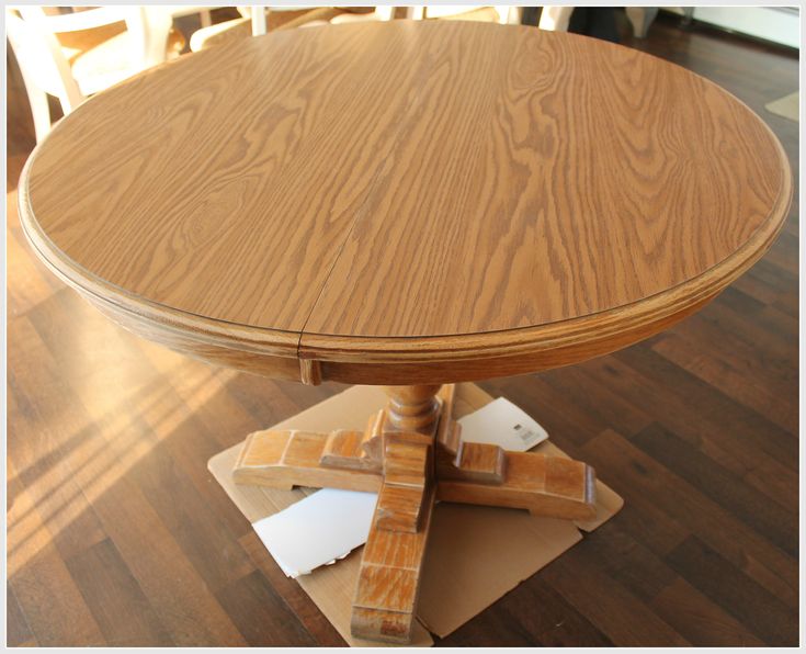 a wooden table sitting on top of a hard wood floor covered in white paper and cardboard