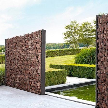 an outdoor area with stone walls and water feature