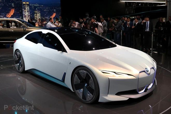 an electric car is on display in front of a group of people at a convention