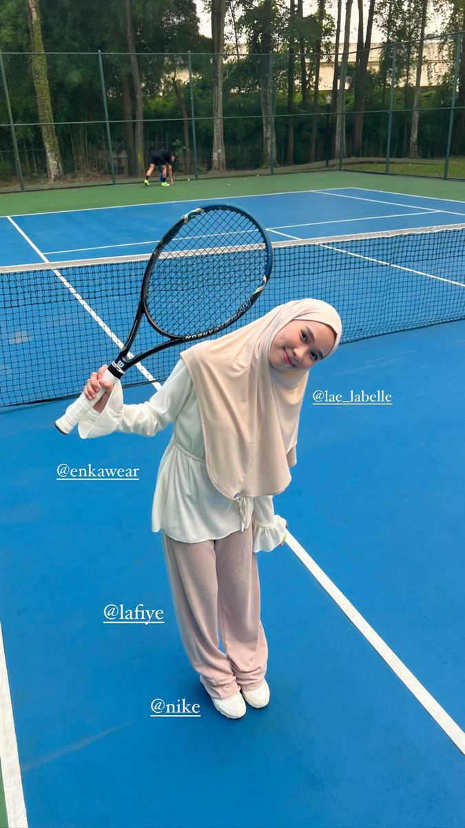 a woman standing on top of a tennis court holding a racquet in her hand