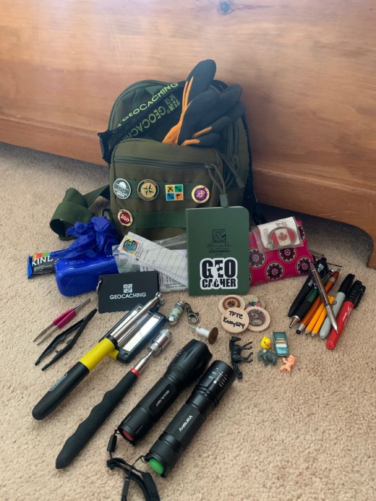 the contents of a backpack are laid out on the floor next to it's contents