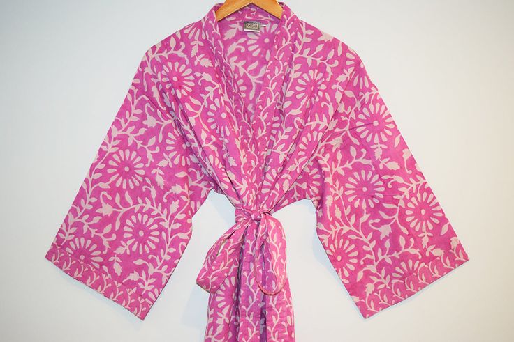 Long cotton kimono robe with stitched placket detail and pockets. Matching belt, interior ties and hanging loop at inside back neck. 100% lightweight cotton | hand block printed in Jaipur, India Size S/M: 45" length | 15" sleeve length | 53" total body width Size L/XL: 47" length | 16" sleeve length | 62" total body width Machine wash cold in water on delicate cycle | Air dry Traditional Cotton Block Print Kimono, Cotton Robe With Tie Waist, Long Sleeve Cotton Robe With Tie Waist, Pink Long Sleeve Cotton Kimono, Long Sleeve Pink Cotton Kimono, Traditional Cotton Robe For Home, Traditional Cotton Home Robe, Traditional Cotton Robe With Kimono Sleeves, Traditional Cotton Robe For Spring