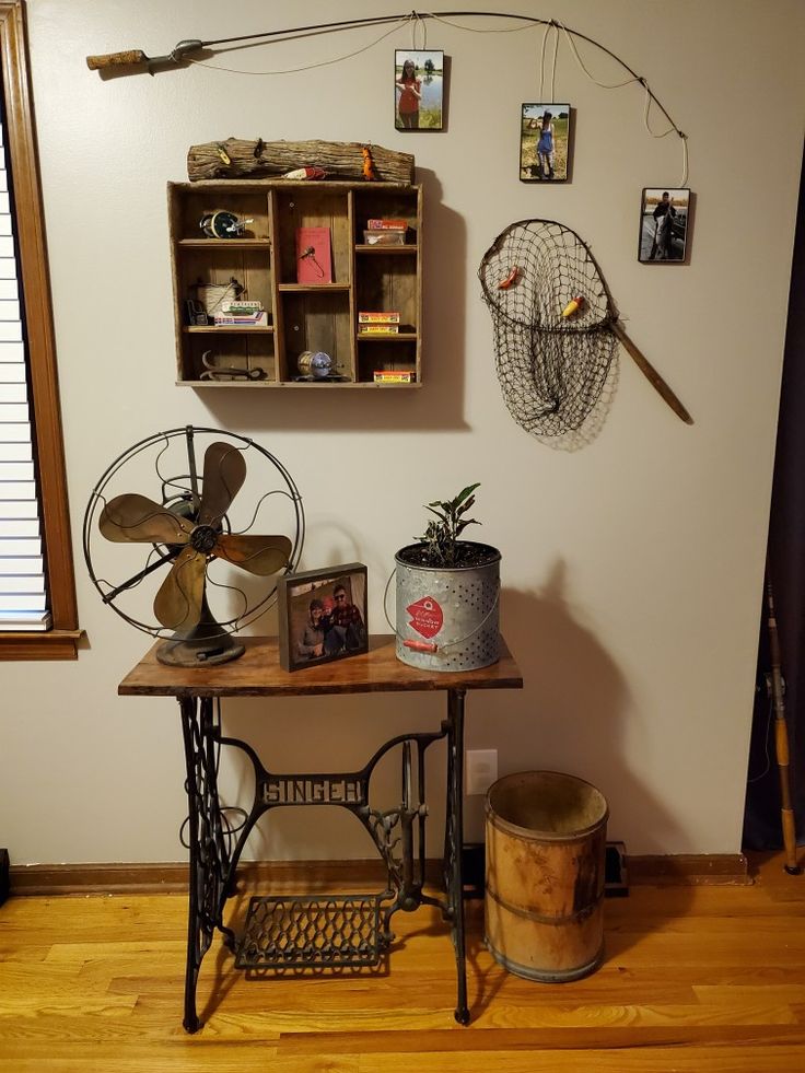 an old sewing machine sits on top of a table in front of a wall with pictures