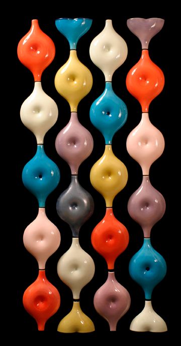 an assortment of different colored vases sitting next to each other on a black background