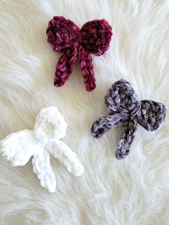 three crocheted bows laying on top of white fur