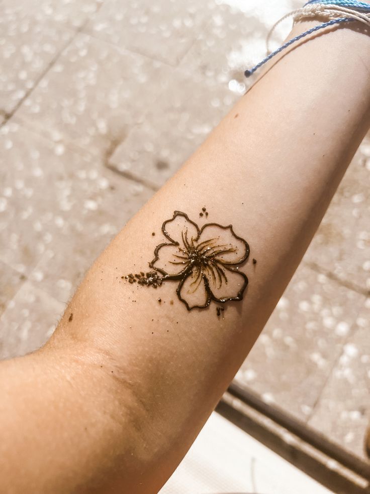 a person with a flower tattoo on their arm