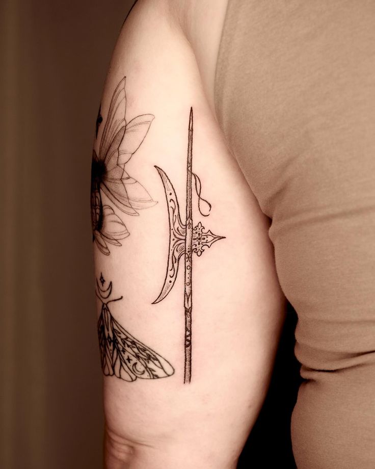 a woman with a tattoo on her arm holding a knife and sunflowers in the background