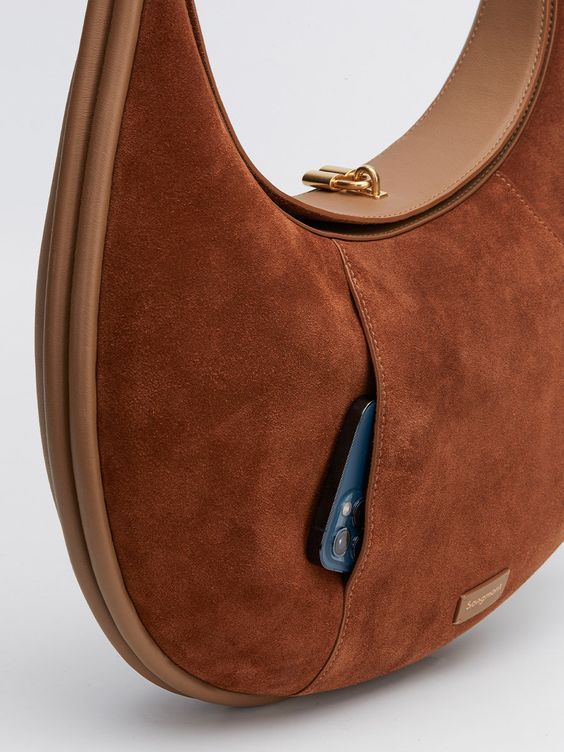 Cette nouvelle version du grand sac Luna a été redimensionnée en fonction des retours des utilisateurs pour offrir une meilleure adaptabilité. L'extérieur de ce sac est en cuir nappa doux et en cuir suédé avec une texture veloutée pour un style personnalisé et haut de gamme.
Le sac est équipé d'une fermeture magnétique sur le dessus, facilitant l'accès à son contenu. À l'avant, une poche discrète et astucieuse assure à la fois protection et sécurité. À l'intérieur, une poche plaquée vous permet d'organiser vos objets essentiels en toute simplicité. Les éléments métalliques, inspirés des assemblages traditionnels à mortaise et tenon, offrent au sac la possibilité de changer de forme, renforçant ainsi sa polyvalence et son élégance.
DÉTAILS & DIMENSIONS
- Matériaux : Cuir de vachette pleine Designer Leather Hobo Bag For Work, Chic Bag With Top Handle And Suede Lining, Chic Top Handle Bag With Suede Lining, Suede Shoulder Bag With Suede Lining For Work, Modern Formal Bag With Suede Lining, Luxury Workwear Bags With Suede Lining, Chic Bag With Suede Lining And Top Handle, Modern Suede Bags For Work, Chic Leather Bag With Suede Lining