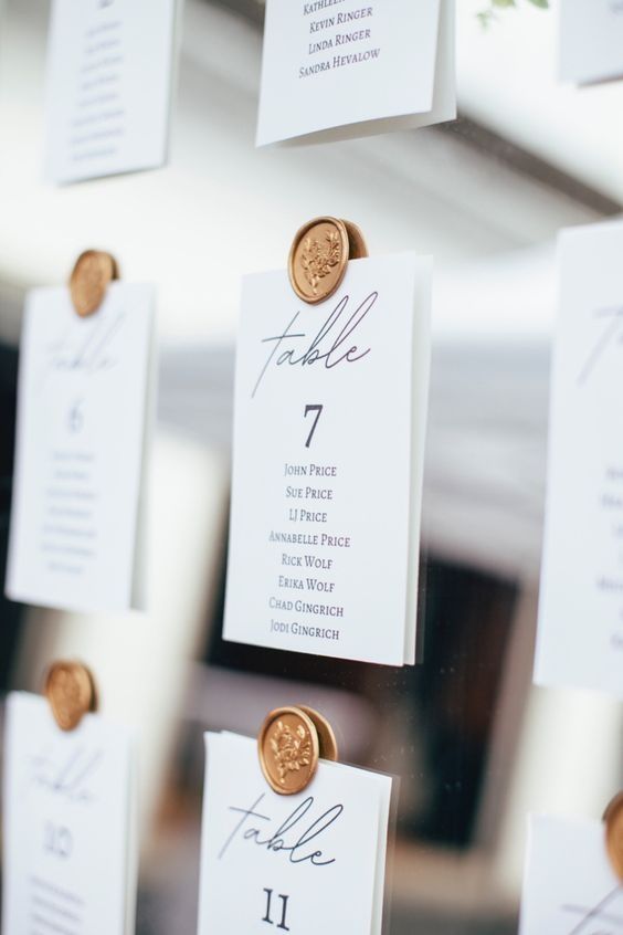 the table numbers are attached to each other with gold buttons and place cards on them