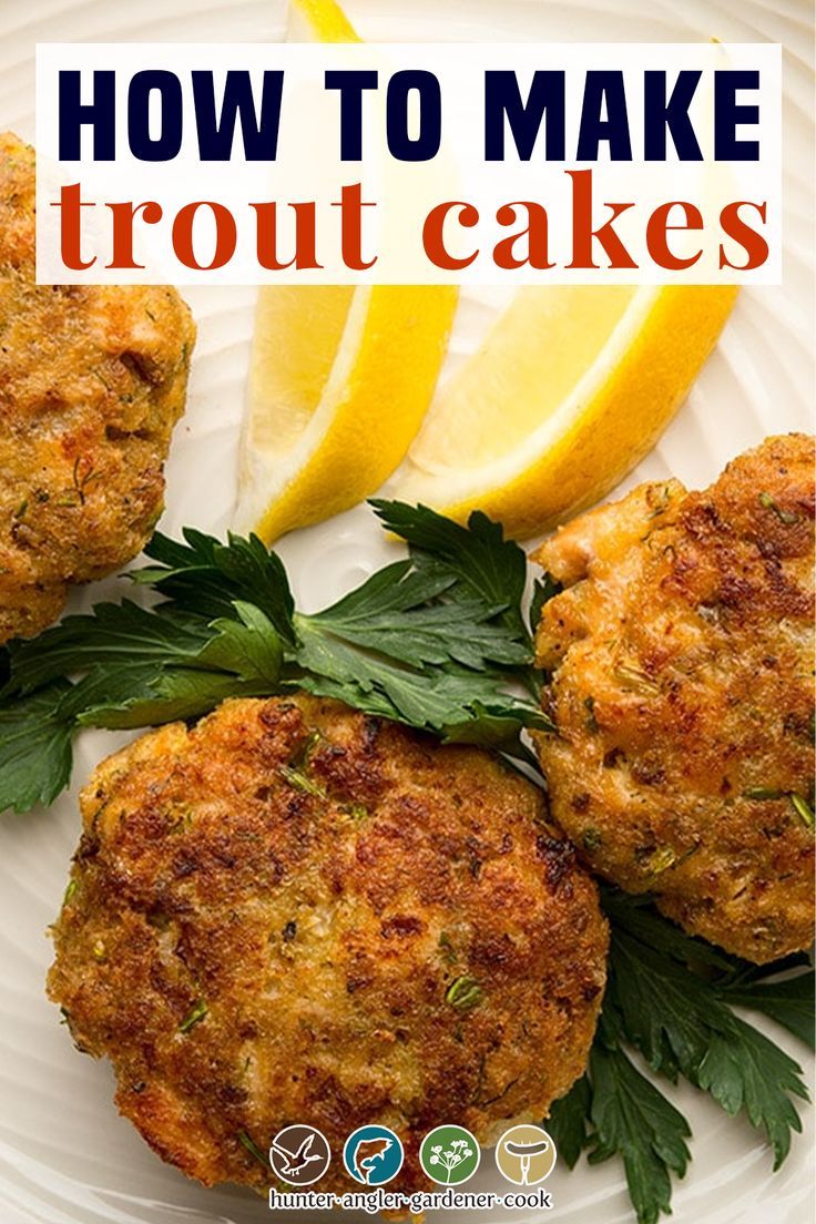 crab cakes on a white plate with lemon wedges and parsley garnish