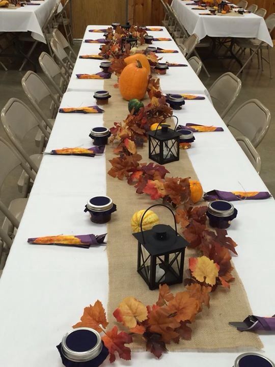 a long table is decorated with fall leaves and candles