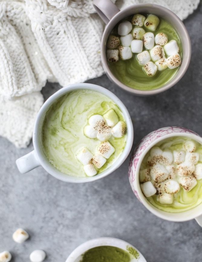 three cups filled with green tea and marshmallows