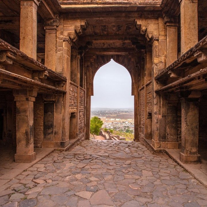 an arch in the middle of a stone walkway