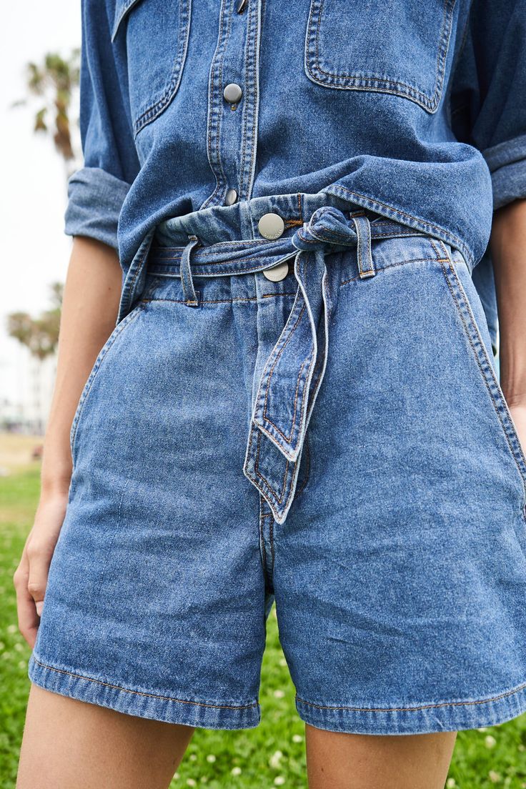 Clara pleated paperbag waist is cinched with a matching detachable belt on these pleat-front denim shorts. Zip fly, duo button closure, cuffed hem, hip side and back pockets. Machine wash cold gentle cycle, dark colors separately, do not bleach. Our model is 5"7 and is wearing a size small Made in Los Angeles Fabric: Light Denim Chic Belted Denim Bottoms, Chic Denim Bottoms With Belt, Chic Belted Denim Blue Bottoms, Belted Denim Blue Bottoms In Denim, Belted Medium Wash Bottoms For Summer, Belted Denim Blue Bottoms, Casual Belted Bottoms In Denim Blue, Casual Denim Blue Belted Bottoms, High Waist Belted Denim Bottoms