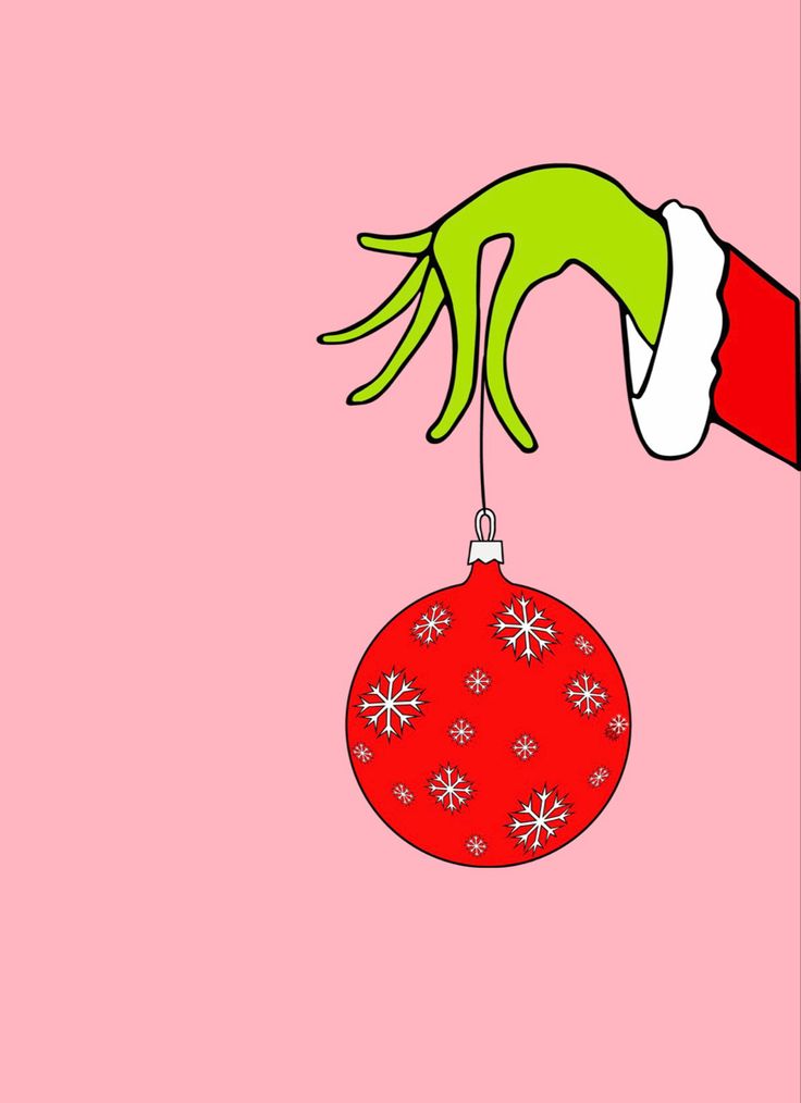 a hand holding a red ornament with snowflakes hanging from it's side