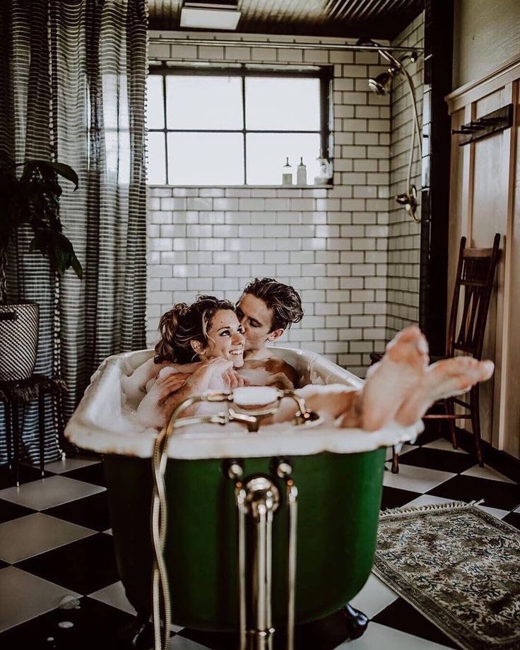 two people in a bathtub with their arms around each other