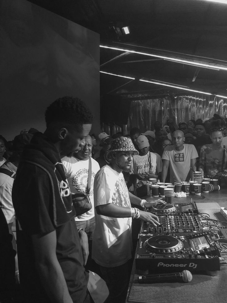 a group of people standing around a dj booth