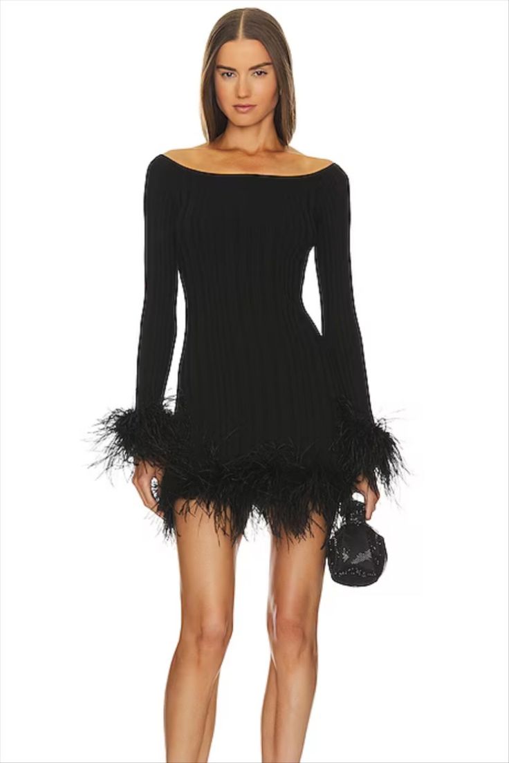 a woman wearing a black dress with feathers on it