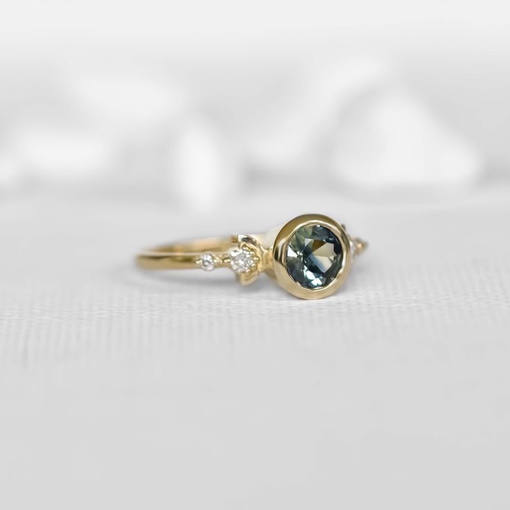 This unique design of modern boho 0.85c parti sapphire engagement ring is truly magical. Inspired by the moon shapes of its orbit cycle, it features a stunning round natural multi-colored parti sapphire captured in a raw bezel circle setting. The 14k yellow gold band is designed with two decorative side boho half moons and 4 side diamonds, making this beauty a one to remember! Perfect for the modern bohemian bride, this ring is sure to be a conversation starter. This ring is ready to ship in US 14k Gold Celestial Sapphire Ring, Unique Yellow Gold Sapphire Ring With Bezel Setting, Sapphire Topaz Ring With Rose Cut Diamonds, Topaz Sapphire Ring With Rose Cut Diamonds, Sapphire Ring With Rose Cut Diamonds, Round Sapphire Ring With Rose Cut Diamonds, Sapphire Birthstone Ring With Rose Cut Diamonds, Modern Sapphire Ring With Rose Cut Diamonds, Unique Sapphire Ring With Rose Cut Diamonds