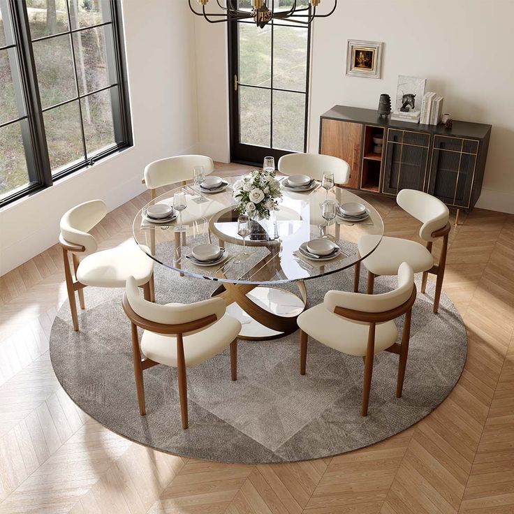 a round glass table with white chairs around it