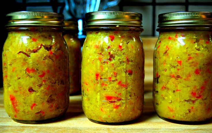 three jars filled with food sitting on top of a wooden table