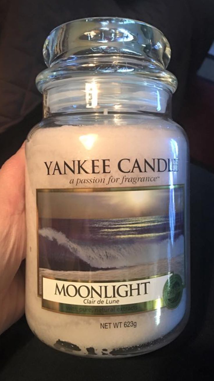 a person holding a candle in their hand with the words yankee candle written on it