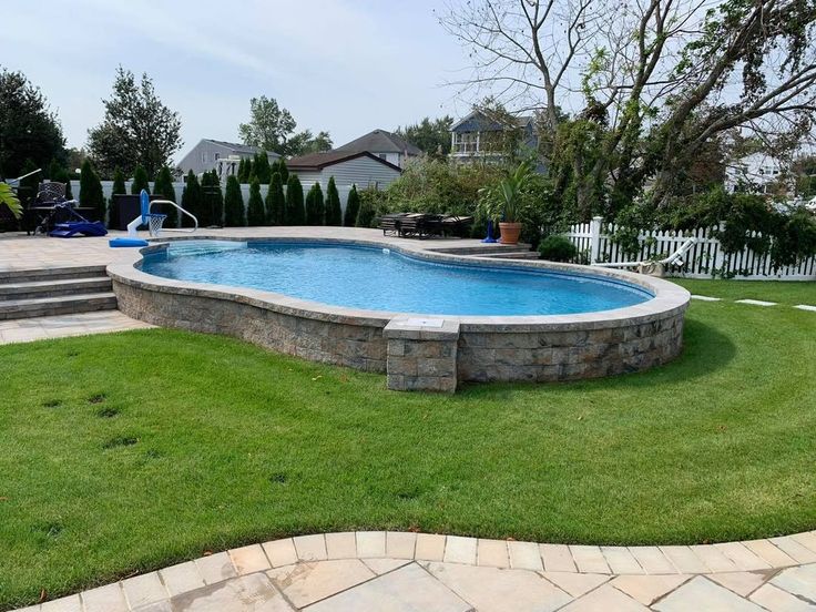 a backyard with a swimming pool surrounded by grass