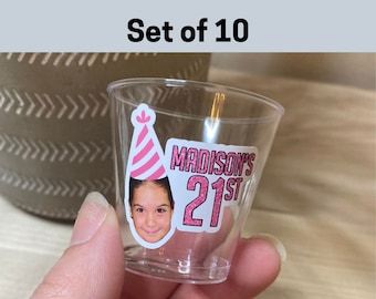 a person holding up a cup with a sticker on it that says, set of 10