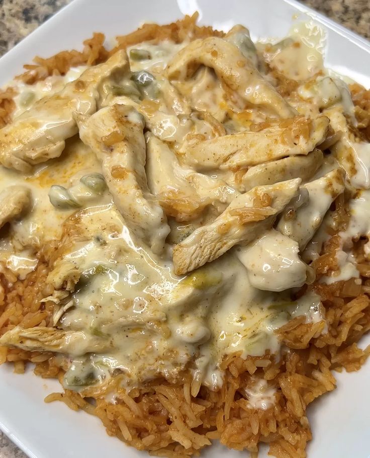 a white plate topped with rice and chicken covered in gravy