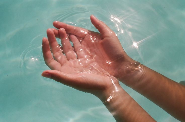 someone is holding their hand out in the water to touch them with both hands,