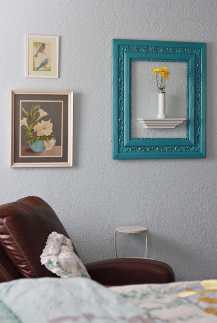 a bedroom with pictures on the wall and a leather chair