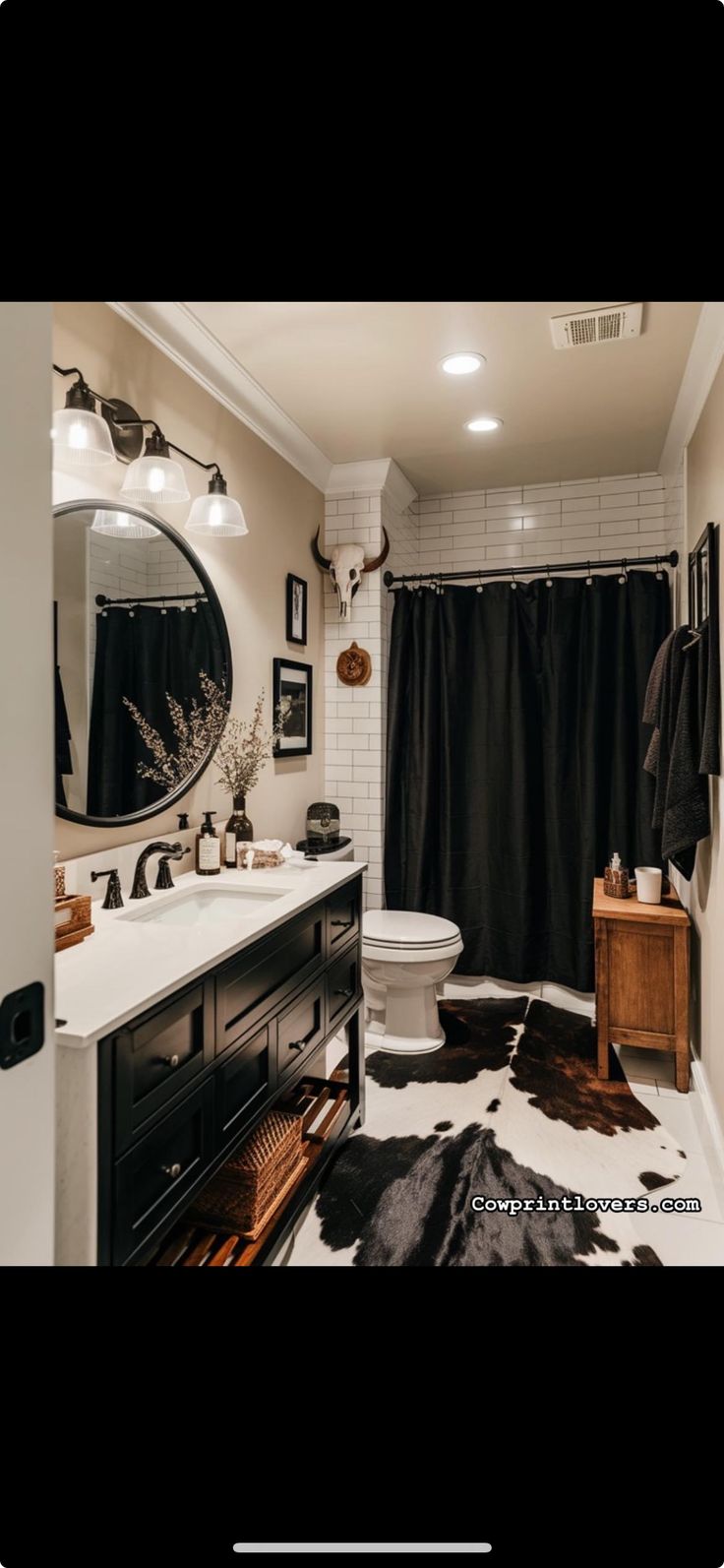 a bathroom with a black and white cow print rug