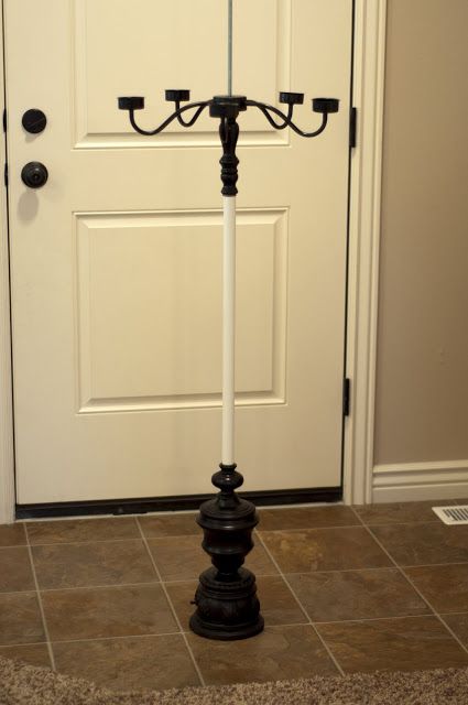 a black and white candle holder in front of a door with two candles on it