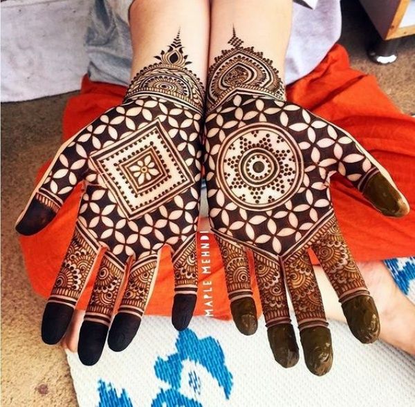 two hands with henna designs on them