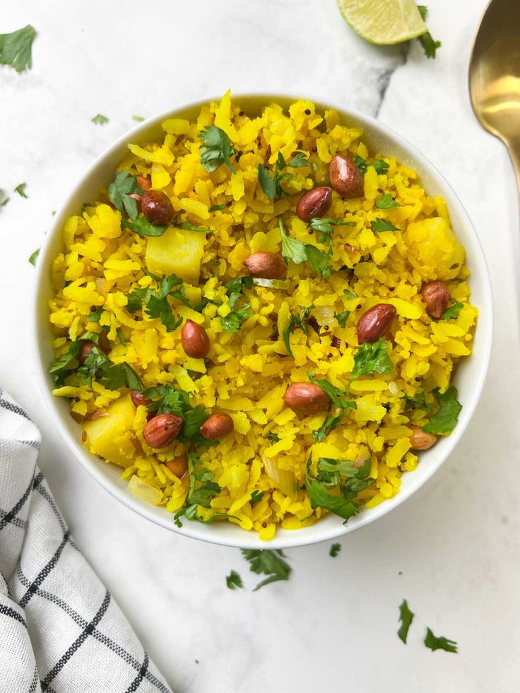 a white bowl filled with yellow rice and beans, garnished with cilantro