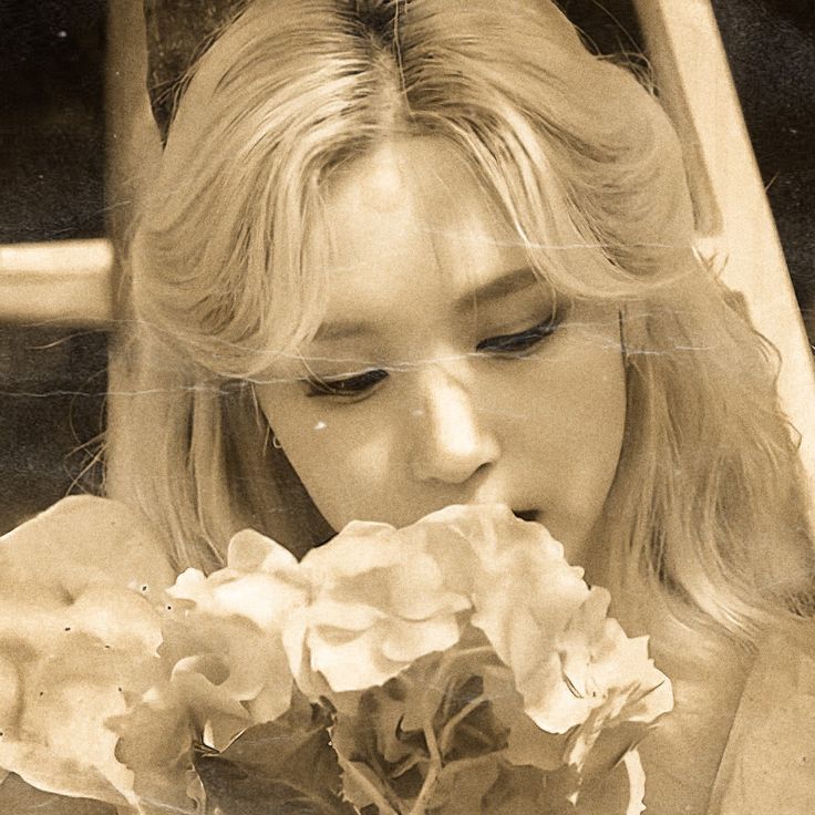 a woman holding a bouquet of flowers in front of her face