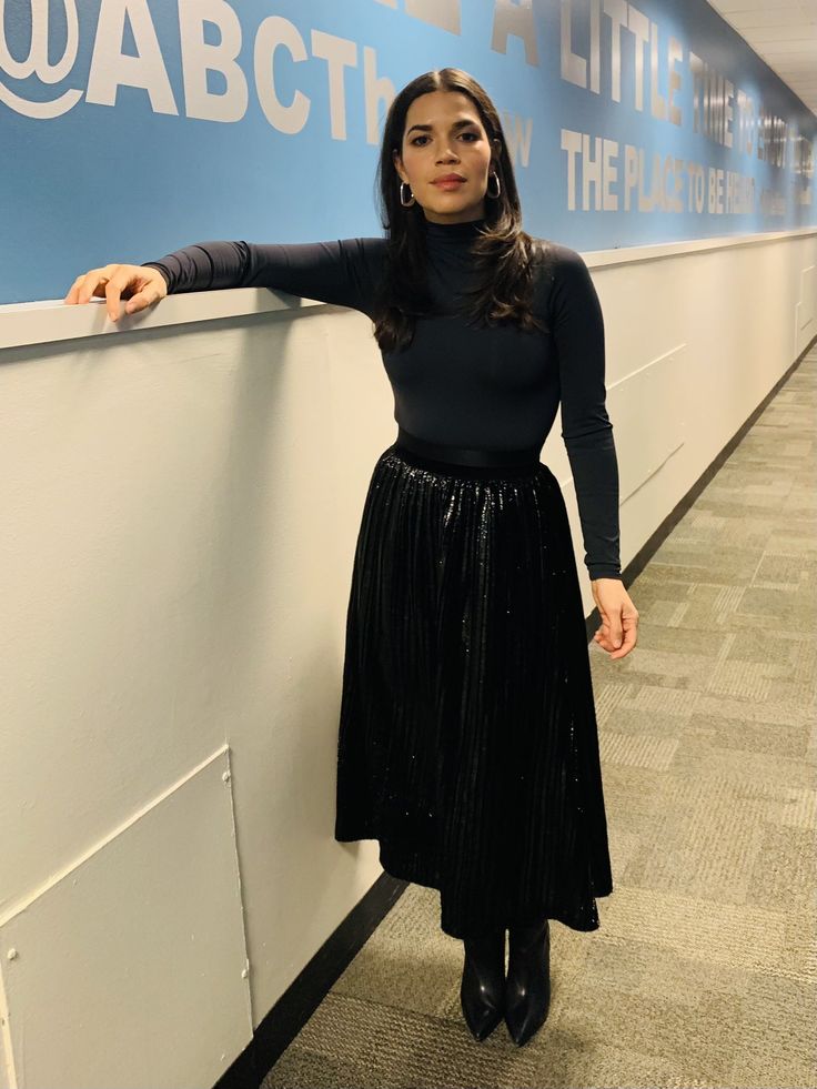 a woman leaning against a wall in an office