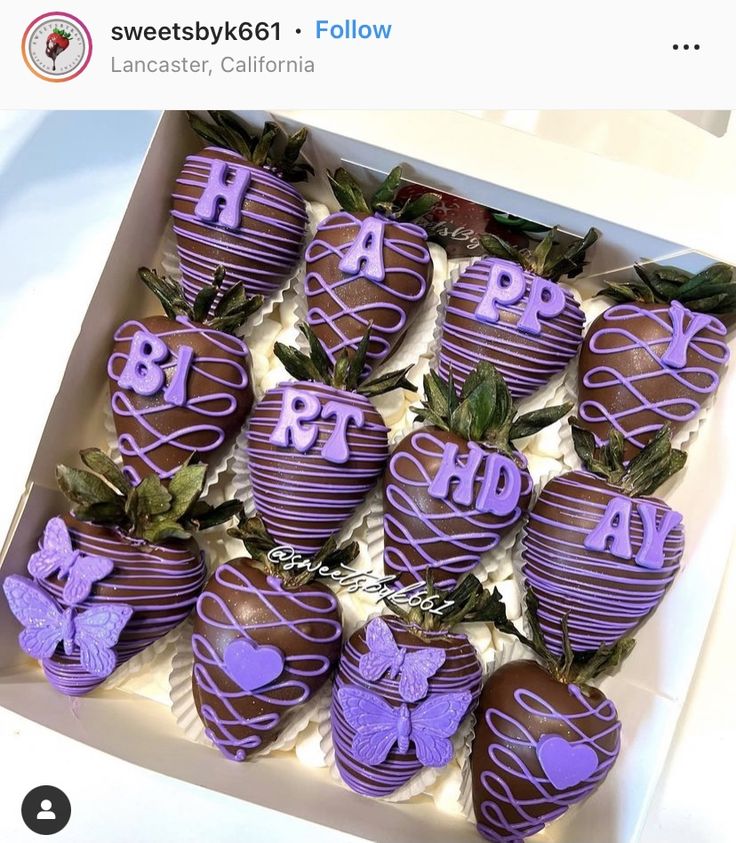 chocolate covered strawberries with purple icing in a white box on top of a table