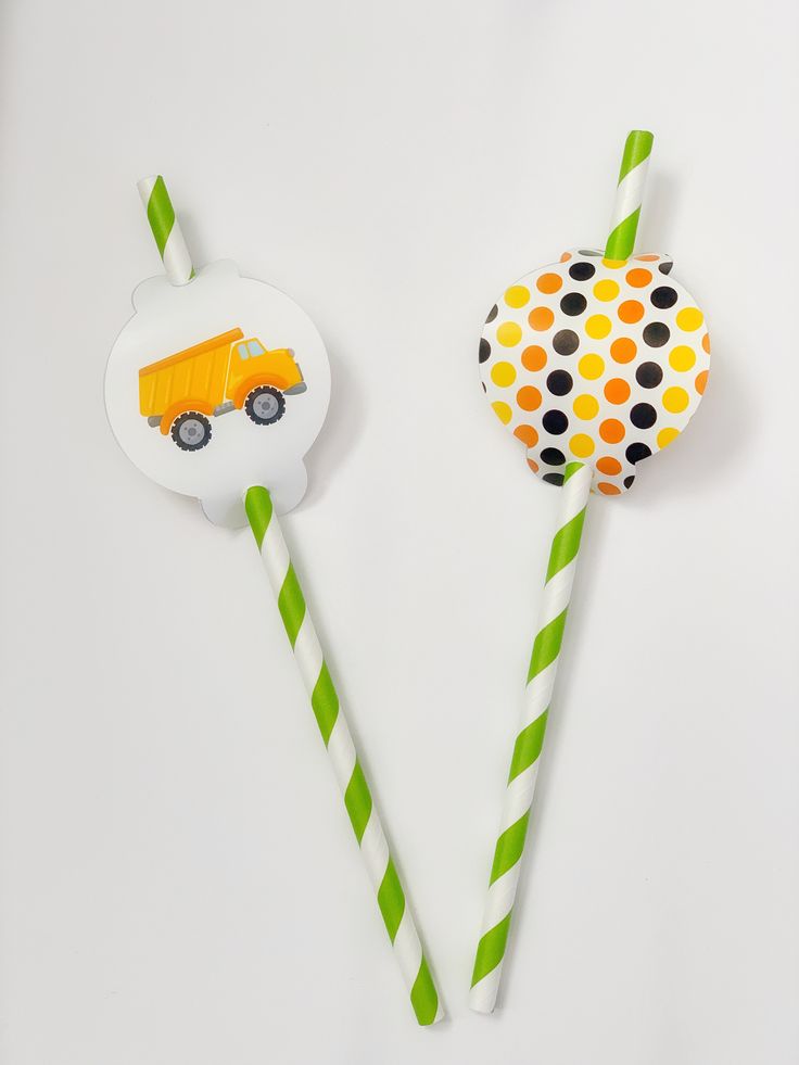 two paper lollipops with construction trucks on them