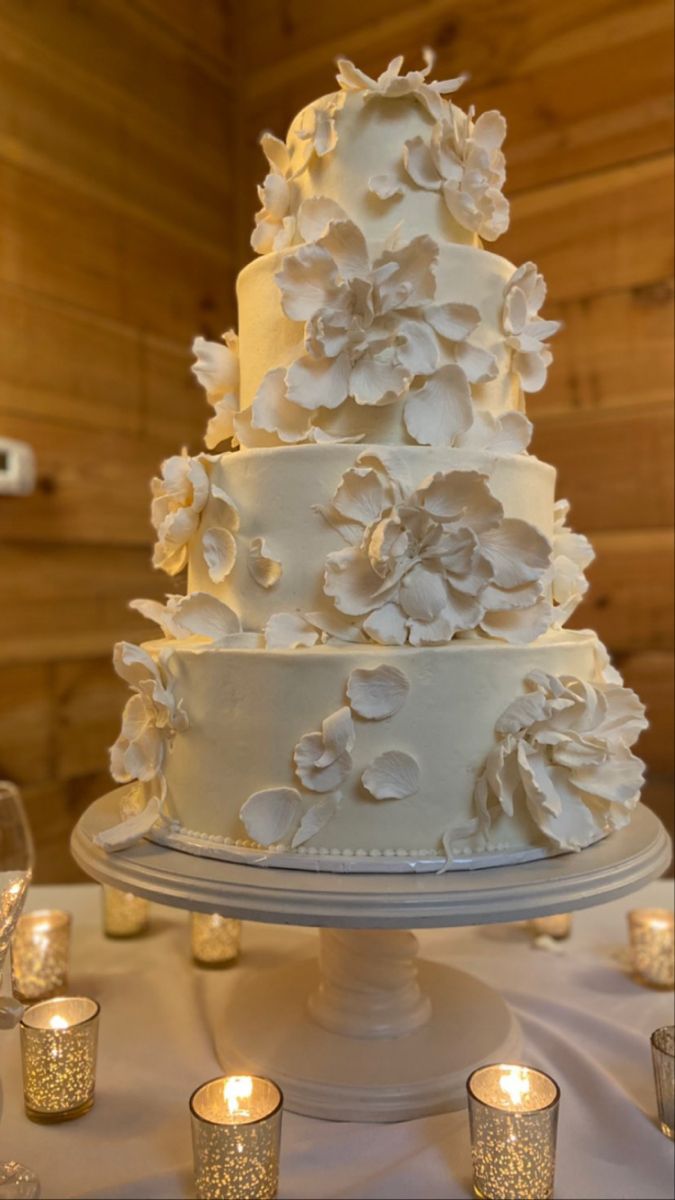 a wedding cake with white flowers and candles