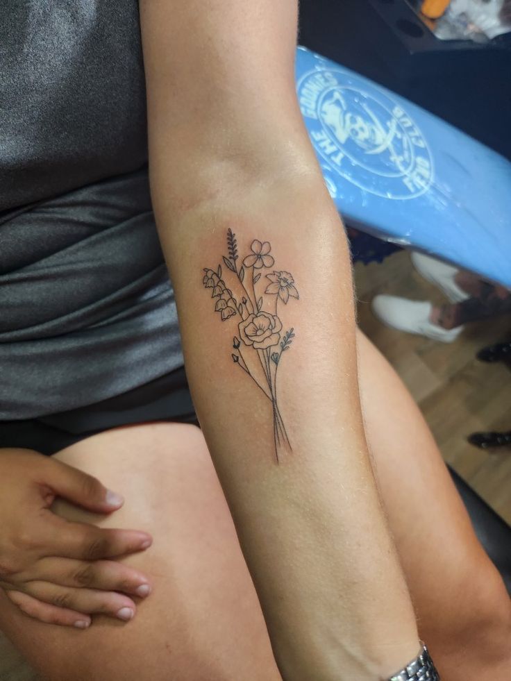 a woman with a flower tattoo on her arm