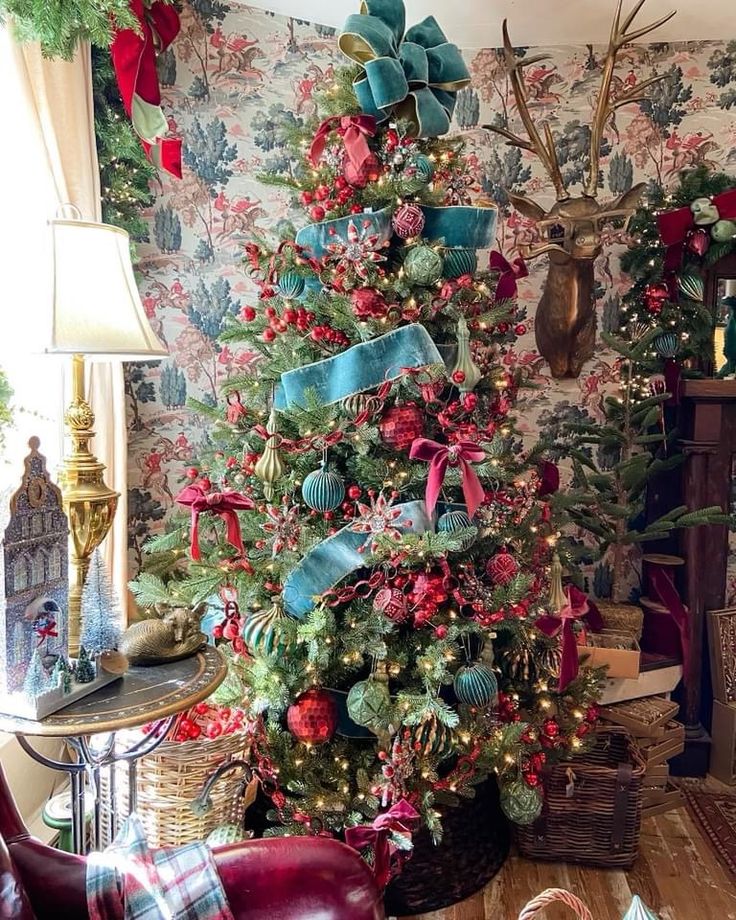 a decorated christmas tree in a living room with deer heads on the wall behind it