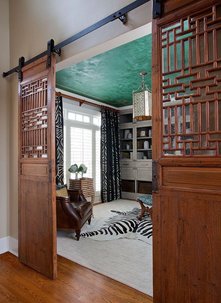 an open door leading to a living room with zebra print rugs on the floor