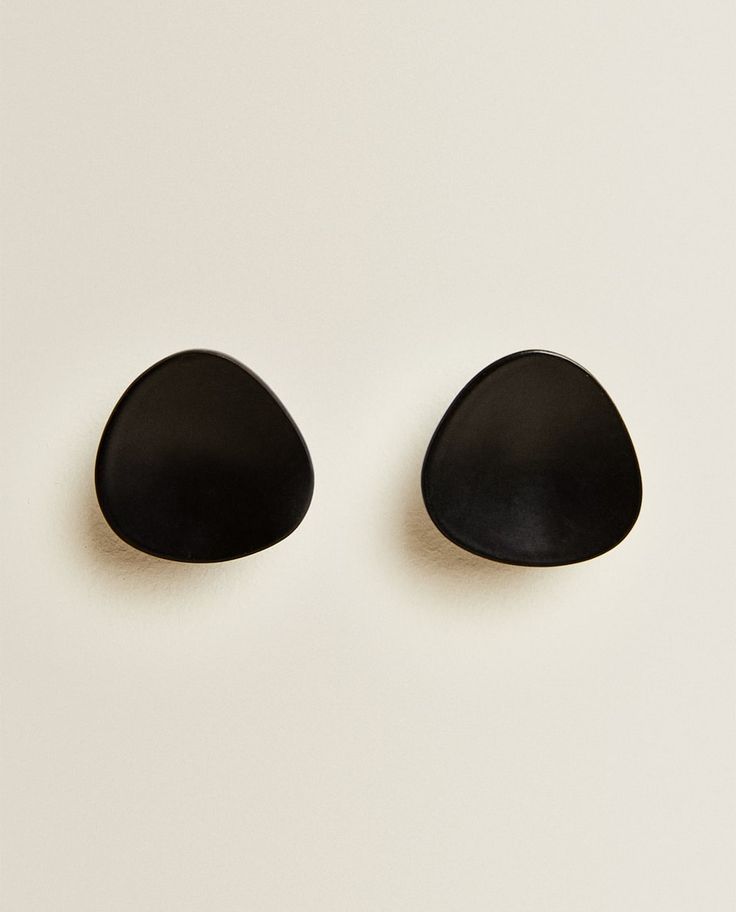 two black stones sitting side by side on a white surface