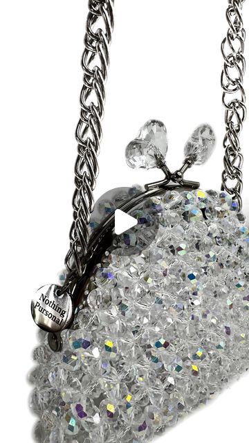 a purse with lots of crystals hanging from it's side on a silver chain